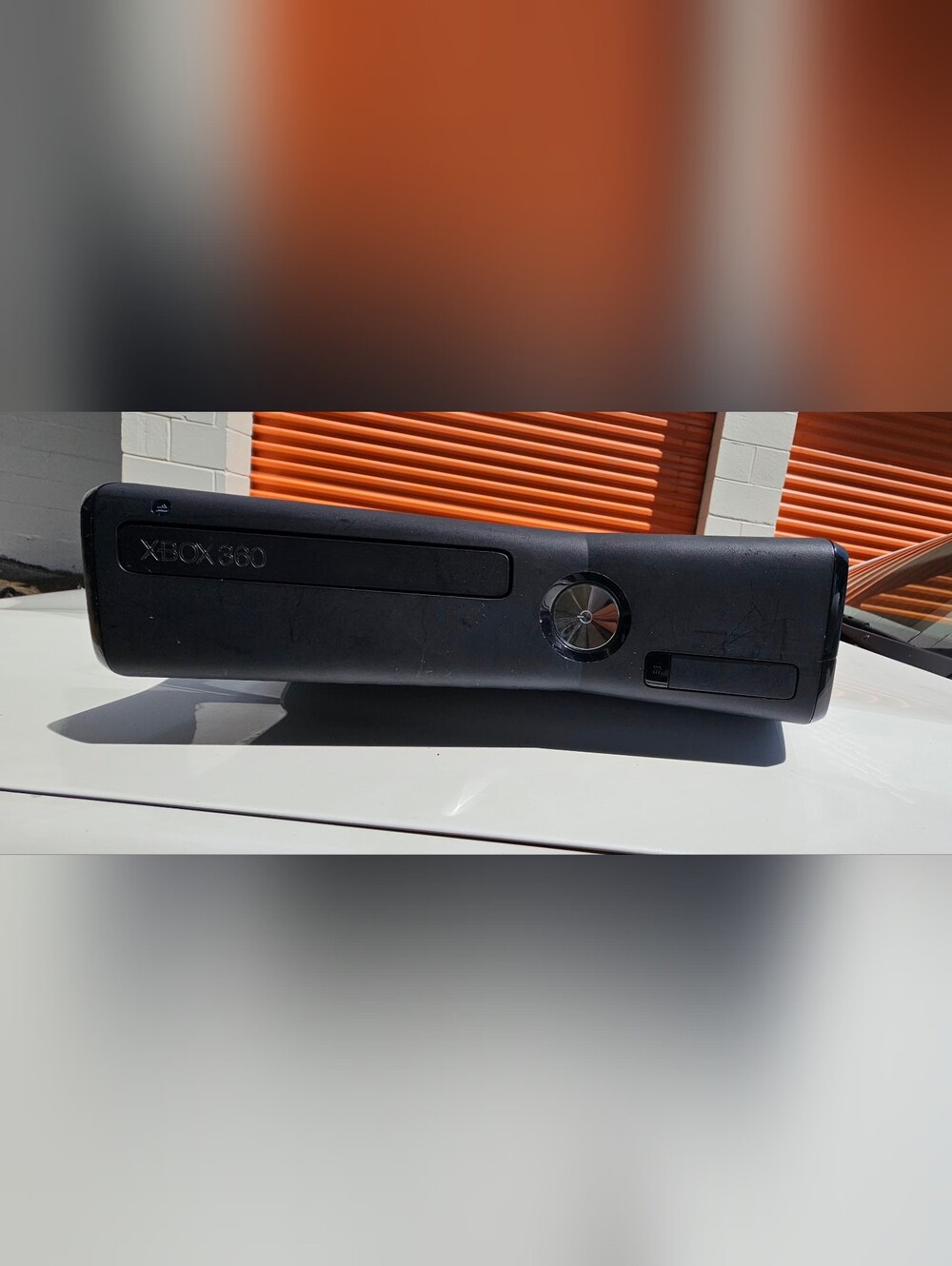 Microsoft Xbox 360 S (Slim) console, featuring a sleek black